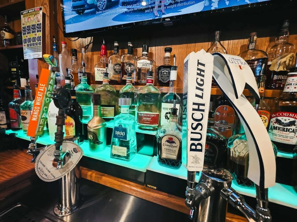 The Vault bar taps and spirit shelf — Busch Light draft, Mango Cart, and full liquor selection