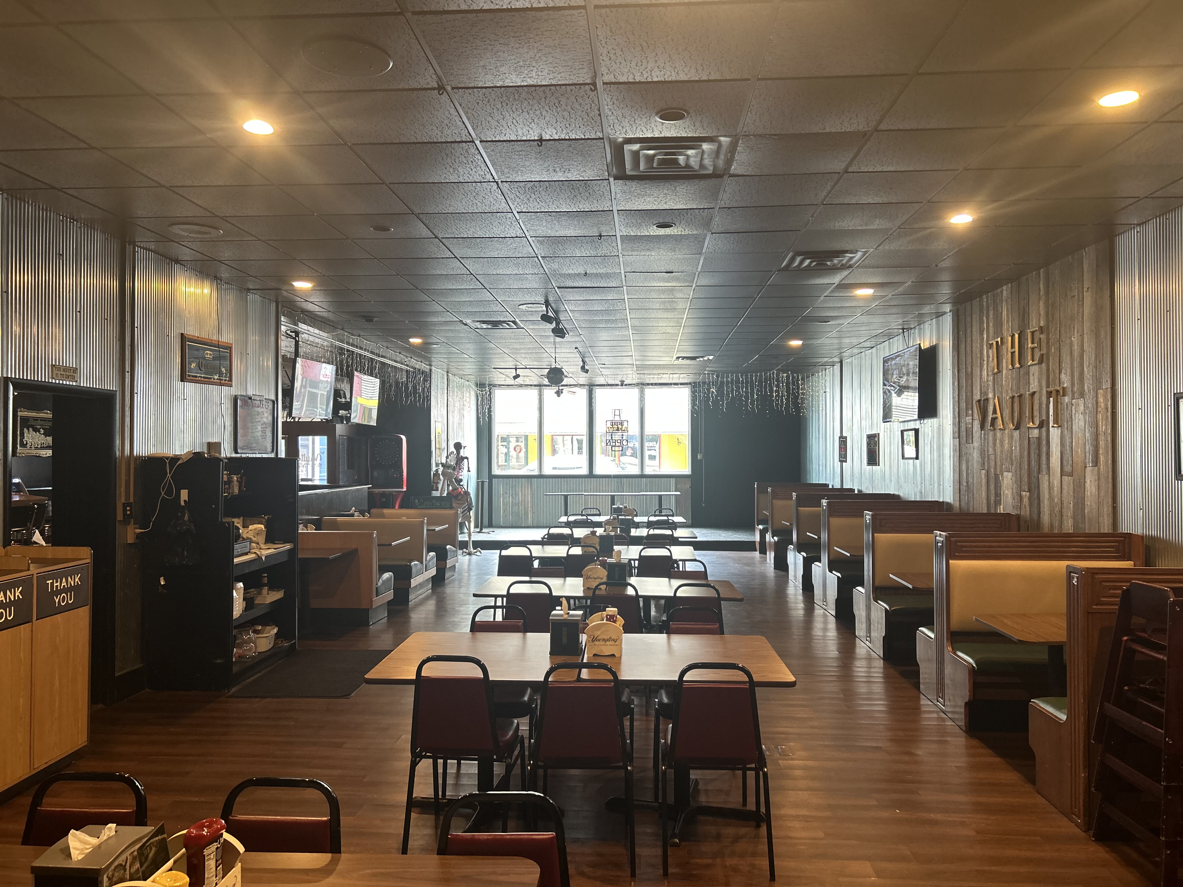 Dining area at The Vault — booths, tables, and THE VAULT sign visible in background
